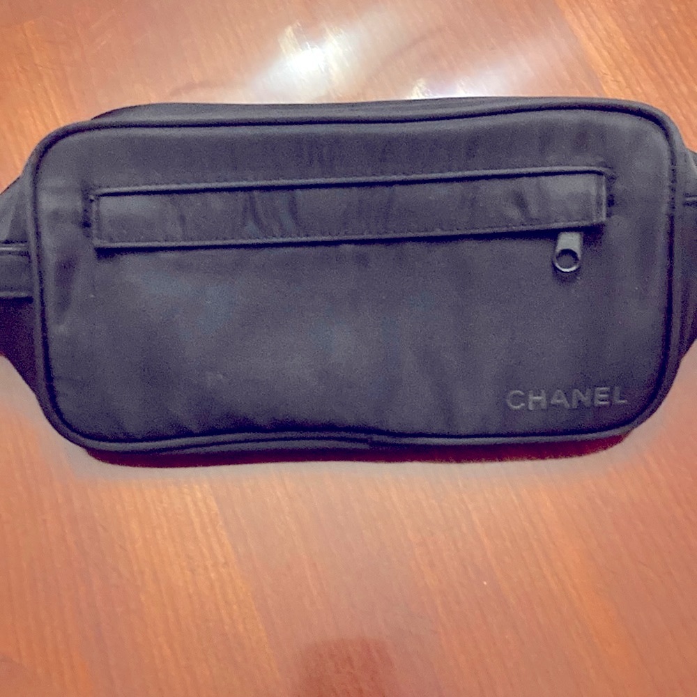 CHANEL TOILETRIES BAG. BLACK. CHANEL PRINTED IN RAISED LETTERS. HAS HANDLE. EUC